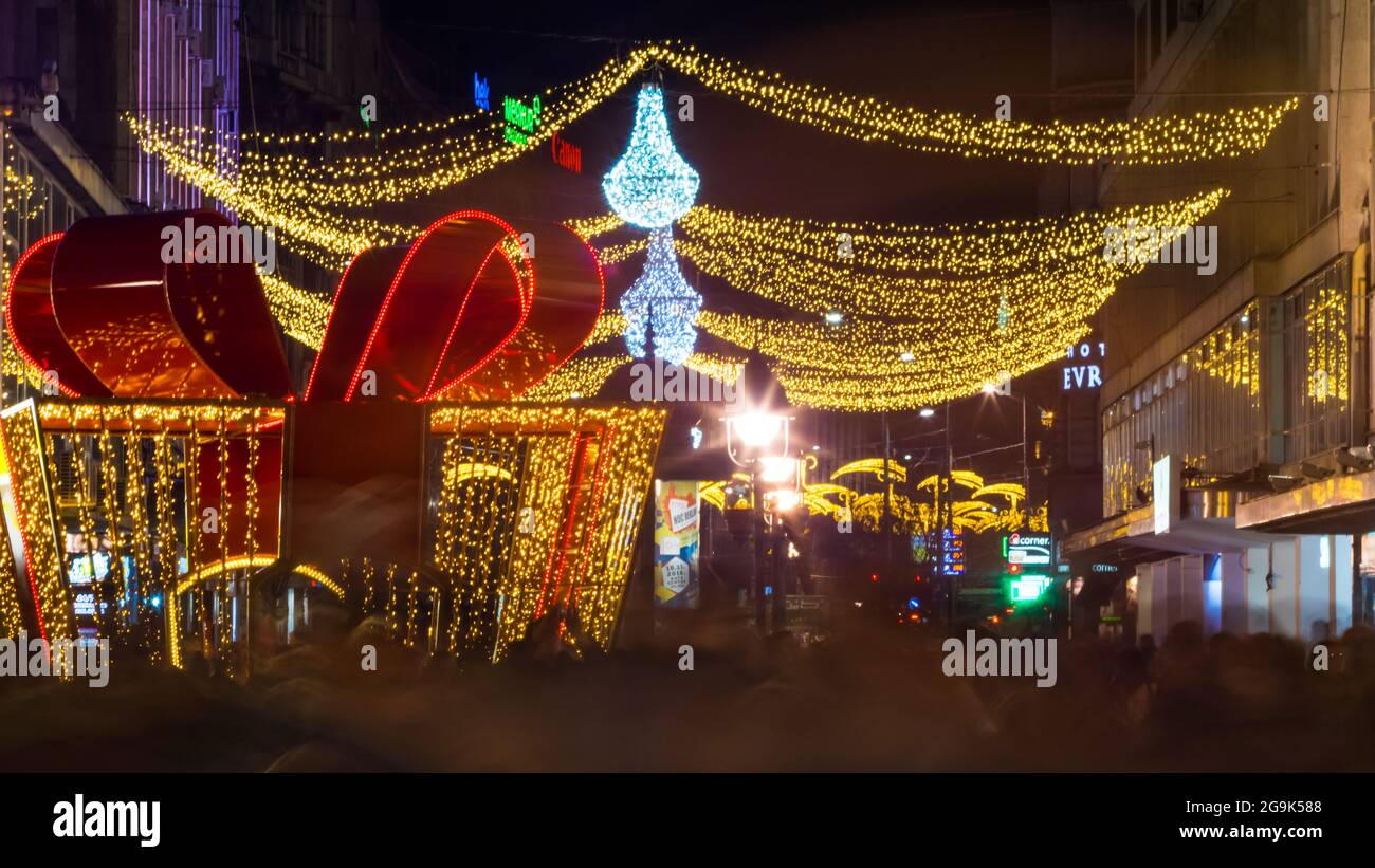 Decorazione di Natale di strada. Folla. Esposizione lunga. Street è decorata per Capodanno / Natale. Le persone festeggiano e fanno shopping. Sbavature. Foto Stock