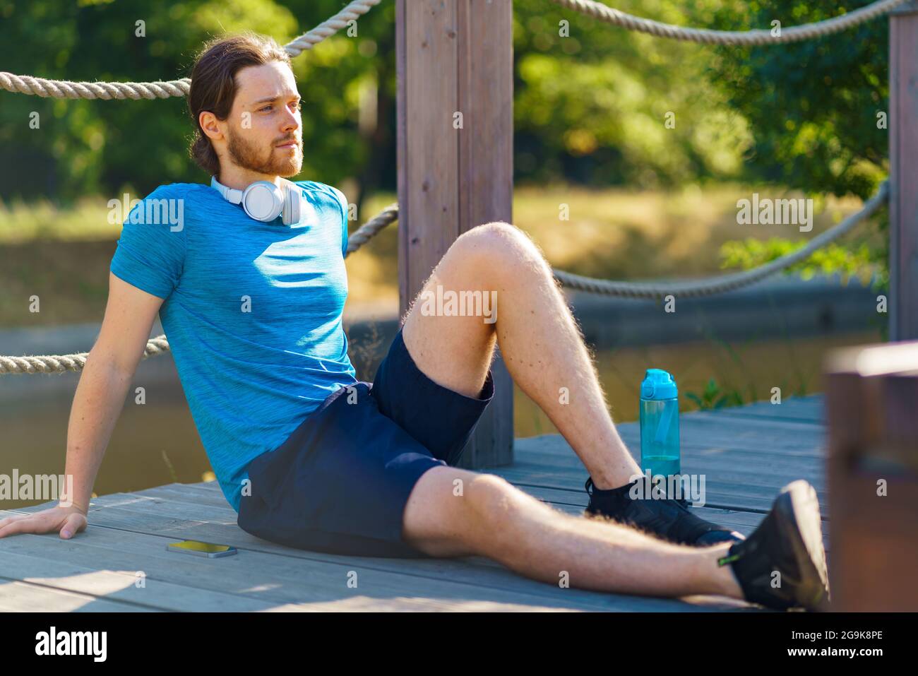 Giovane uomo sportivo rilassato che si rilassa dopo un allenamento all'aperto nella natura Foto Stock