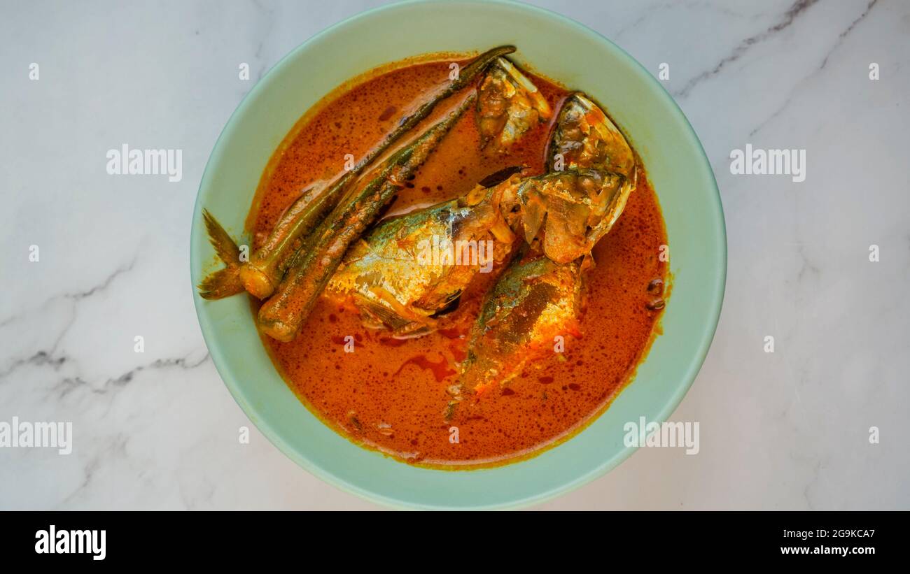Delizioso pesce sgombro fatto in casa curry con la signora dito cotto nel latte di cocco. Piatti molto popolari nella Malesia settentrionale. Foto Stock
