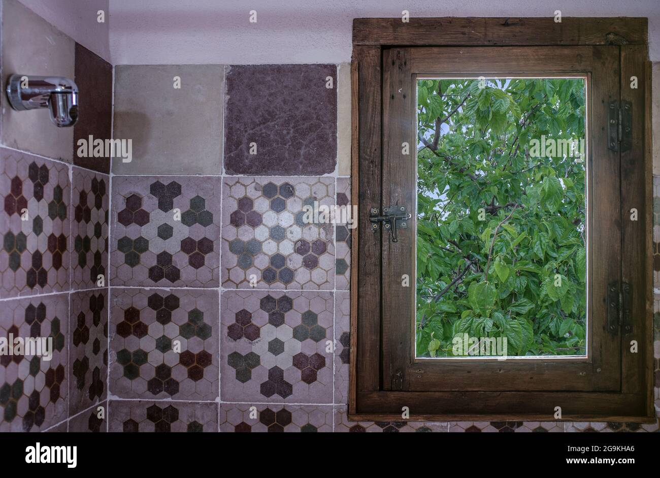 Il bagno rurale d'epoca dell'hotel è coperto da vecchie piastrelle di cemento. Concetto di turismo rurale Foto Stock