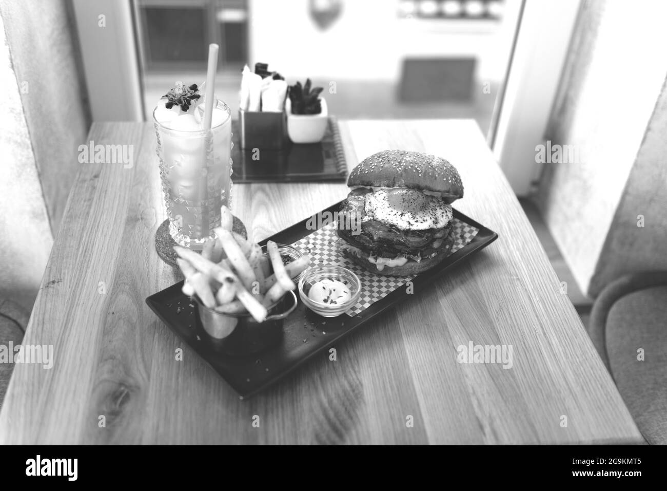 Hamburger con patatine fritte e salsa su un cocktail Dark Table Passion Fruit Mojito Foto Stock