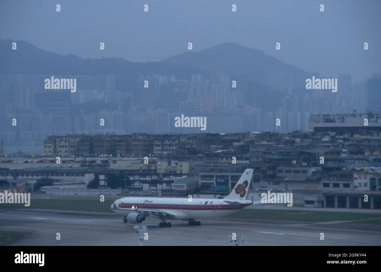 Thailändisches Flugzeug im Anflug auf den alten Flughafen a Hongkong, Cina 1998. Aereo tailandese atterrando sul vecchio aeroporto di Hong Kong, Cina 1998. Foto Stock