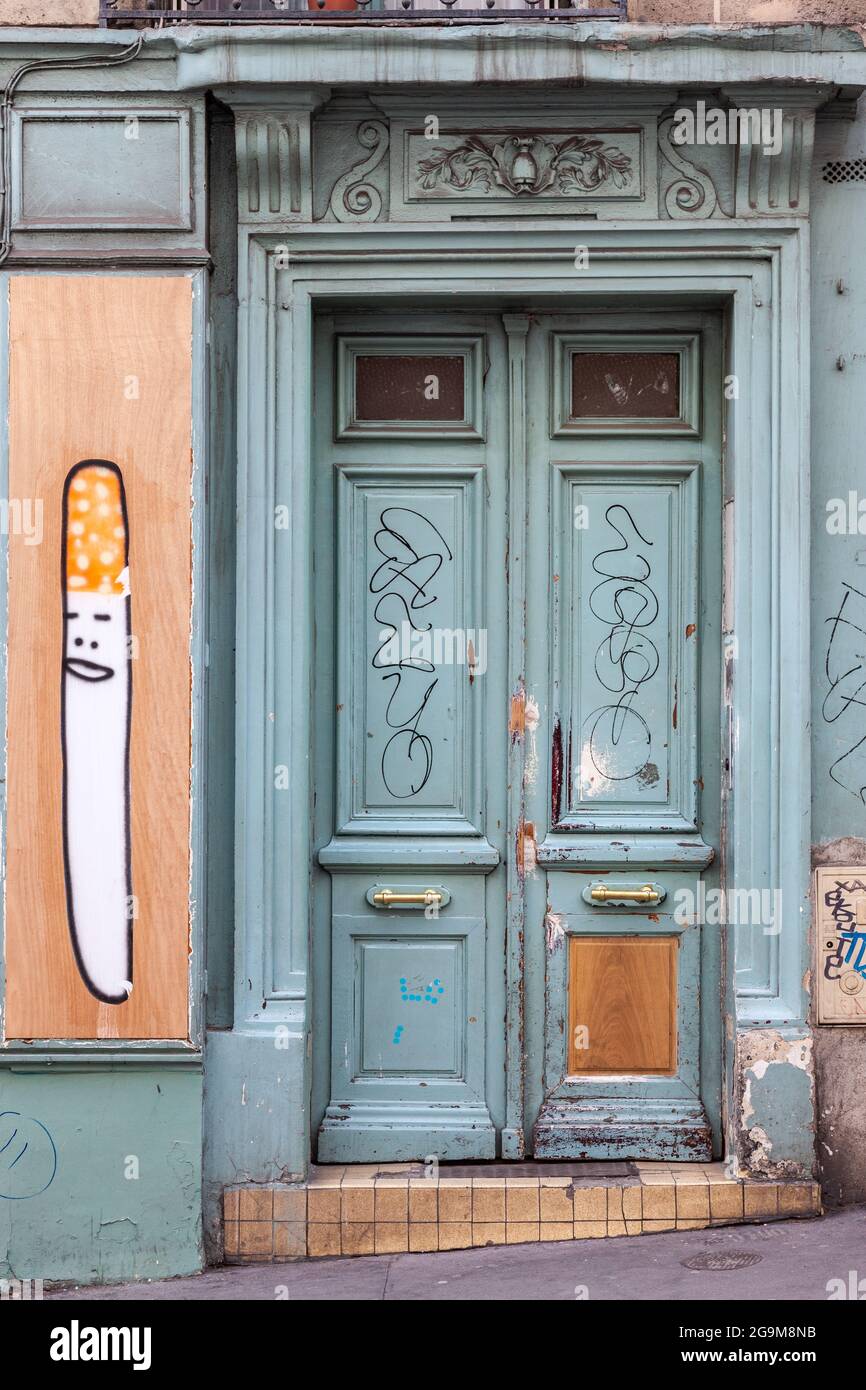 Trascurato porta blu di una strada a Montmartre. graffiti che rappresenta un coltello. Parigi Foto Stock
