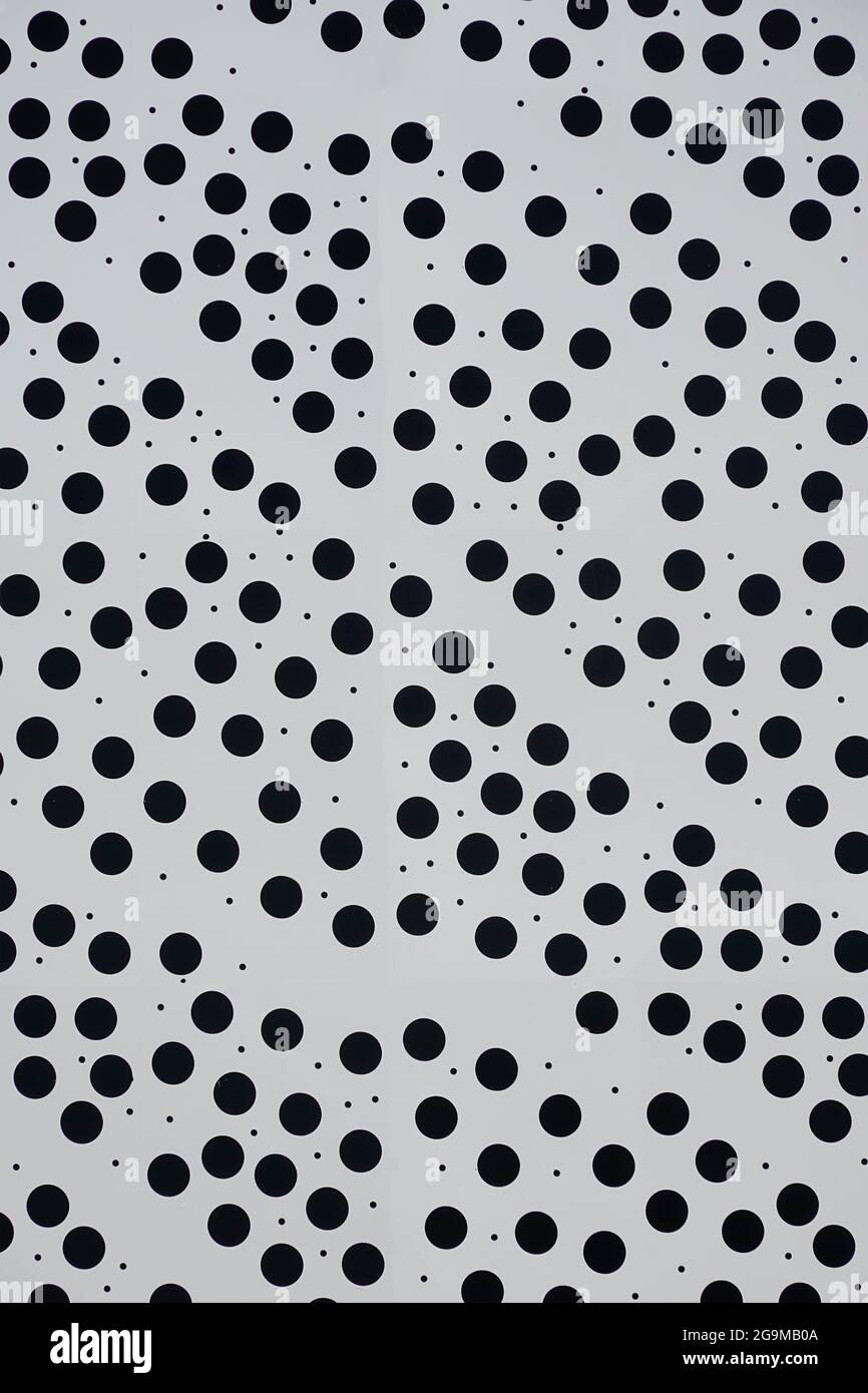 Primo piano astratto di doty bianco sfondo di costruzione pannello di rivestimento dimensioni regolari piccoli circolari nero punti tondi e casuale minuscoli macchie Inghilterra UK Foto Stock