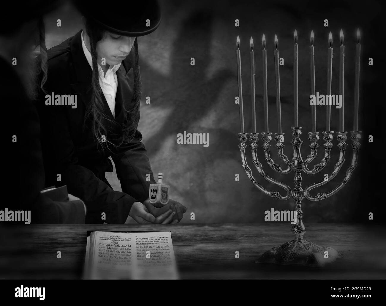 Ragazzo ebraico con dreidel e candele Hannukah Foto Stock