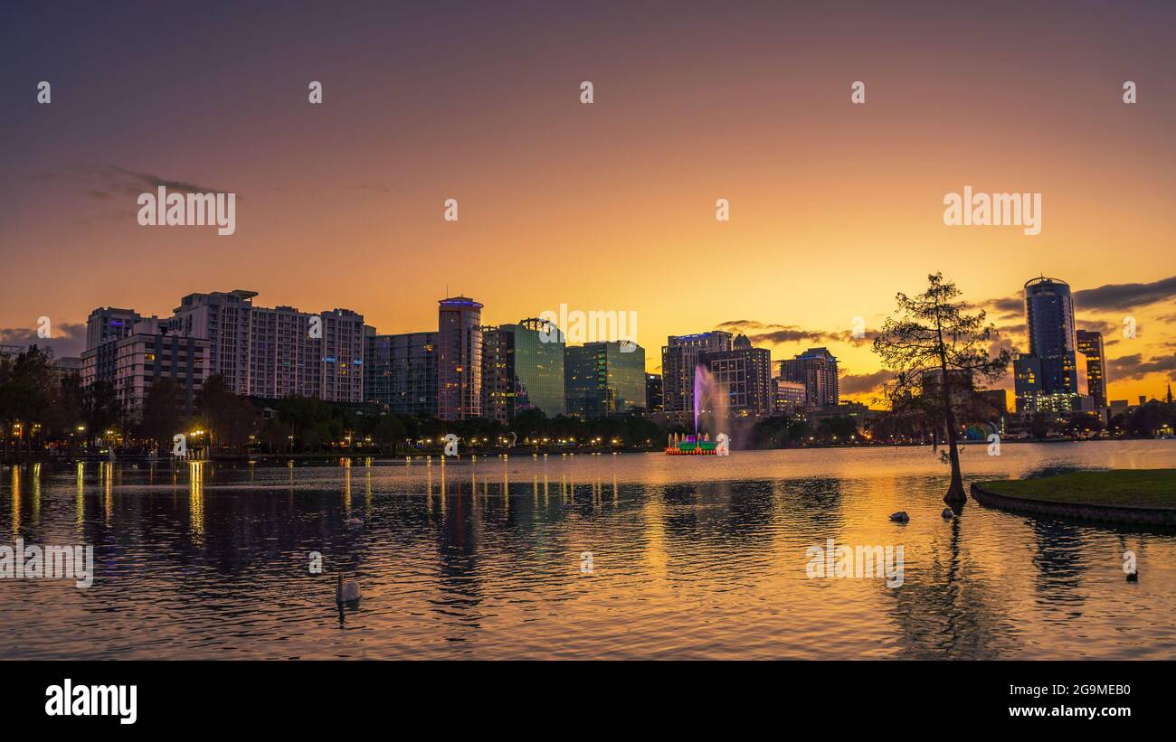Tramonto colorato sopra il lago Eola e lo skyline della città di Orlando, Florida Foto Stock
