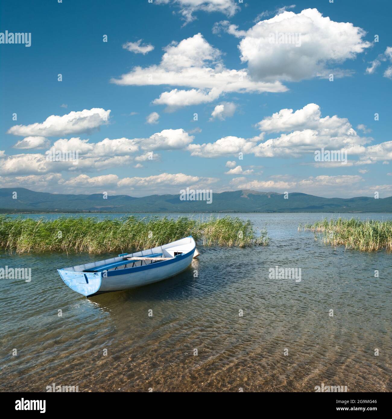 Paesaggio nuvoloso sul lago Prespa con barca a remi, Repubblica di Macedonia Foto Stock