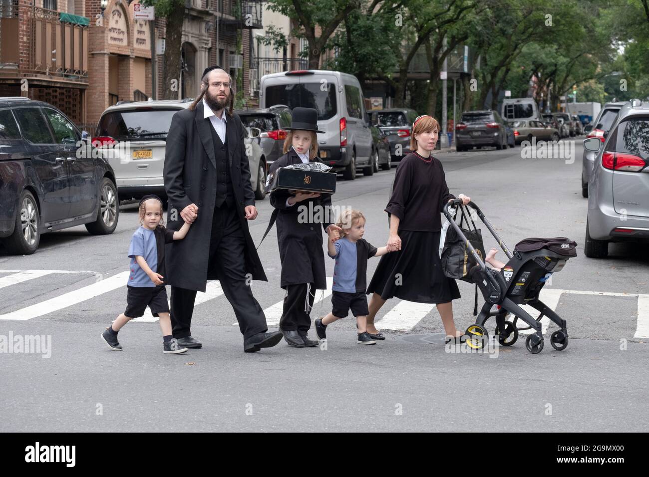 Una famiglia ebraica ortodossa attraversa Bedford Avenue a Williamsburg, Brooklyn, New York City. Foto Stock