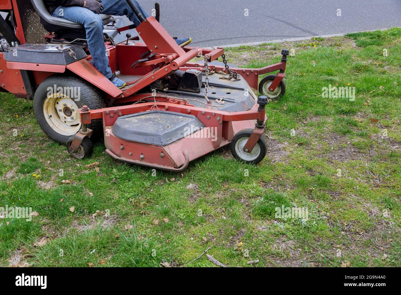 Rasaerba in funzione su prato verde con erba tagliata attrezzatura per la cura del giardino Foto Stock