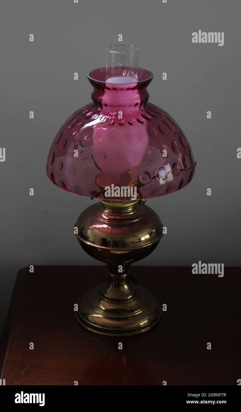 Una lampada in metallo antico con paralume in vetro rosa Foto stock - Alamy