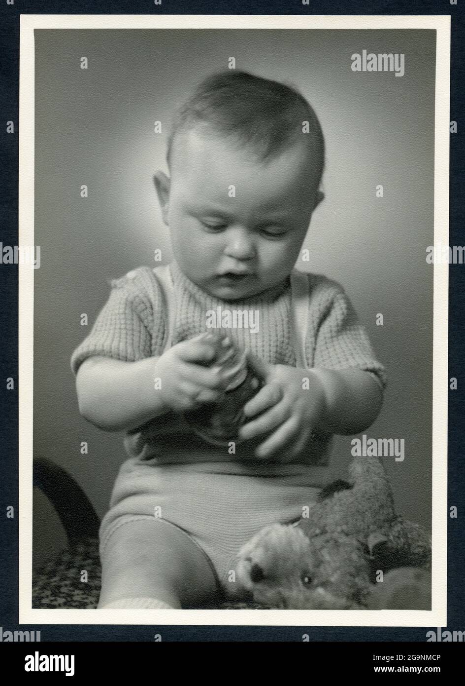 Il bambino è seduto su uno sgabello e sta giocando con un giocattolo, Amburgo, nel 1950 ° , DIRITTI-AGGIUNTIVI-CLEARANCE-INFO-NON-DISPONIBILE Foto Stock