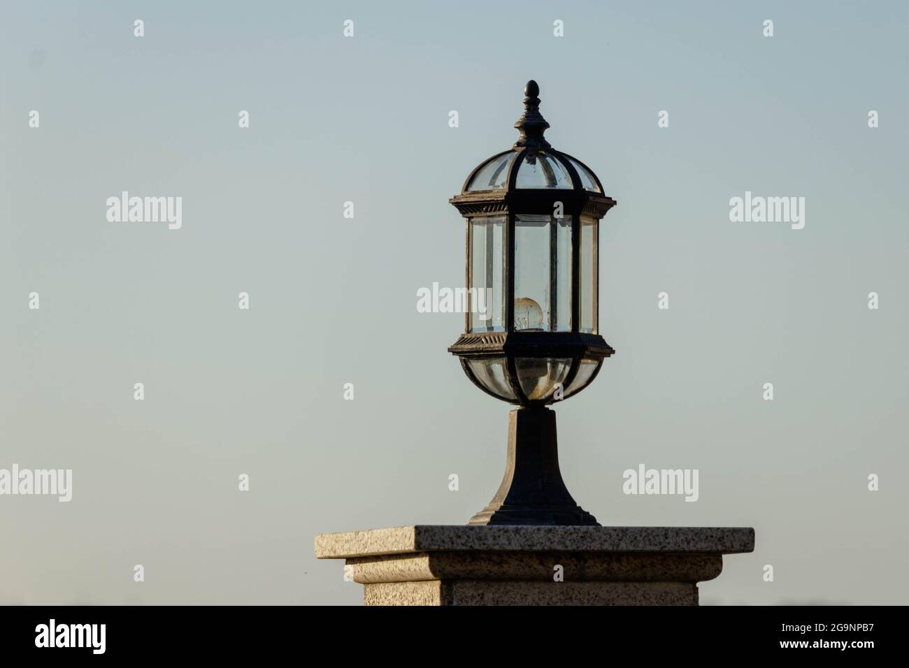Coruna / Spagna - Marzo 20 2021: Lampada da esterno in ottone ornato sulla sommità di un pilastro in marmo Foto Stock