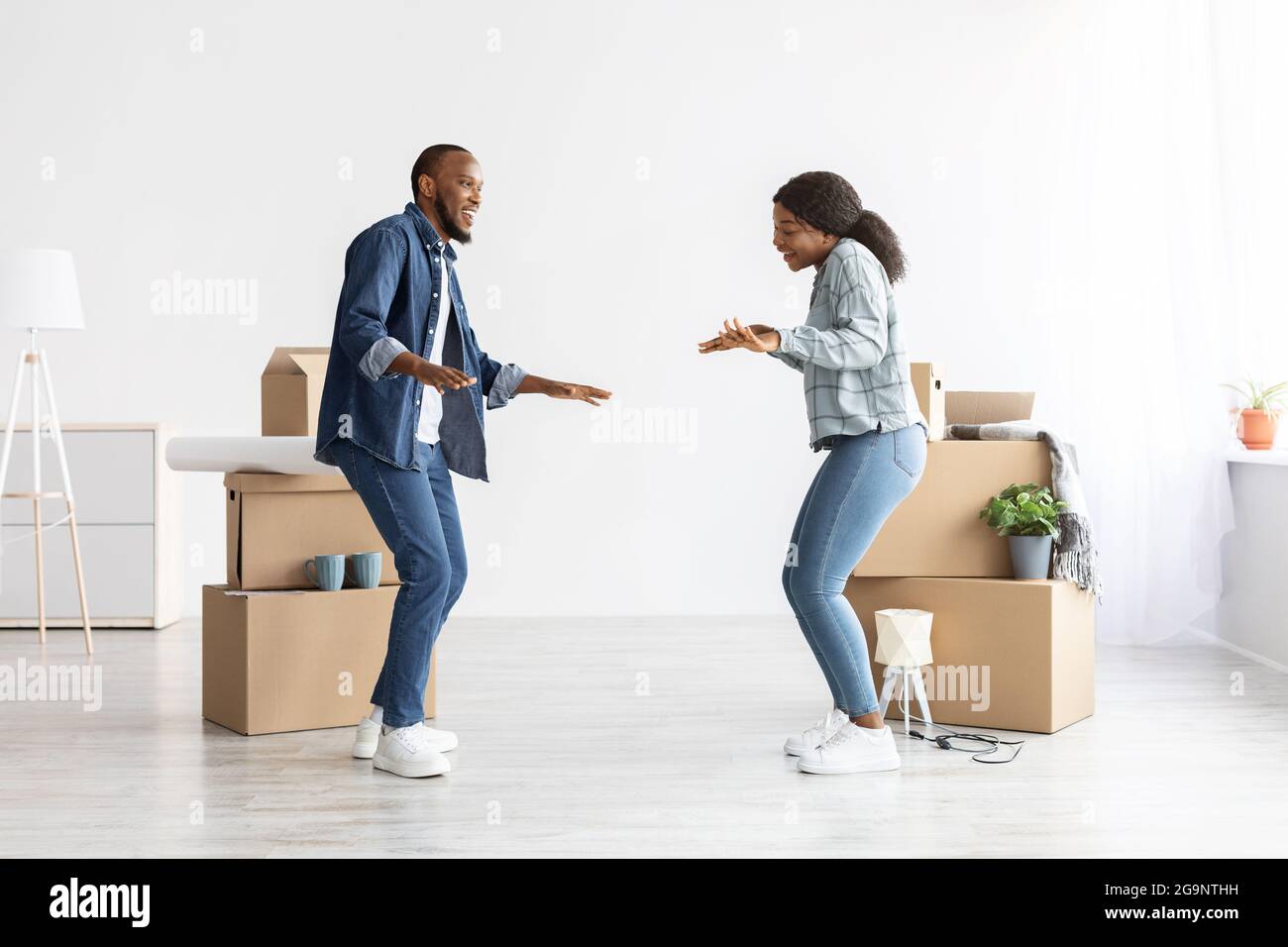 Happy Young Black coniugi Danzare nel loro nuovo appartamento in Moving Day Foto Stock