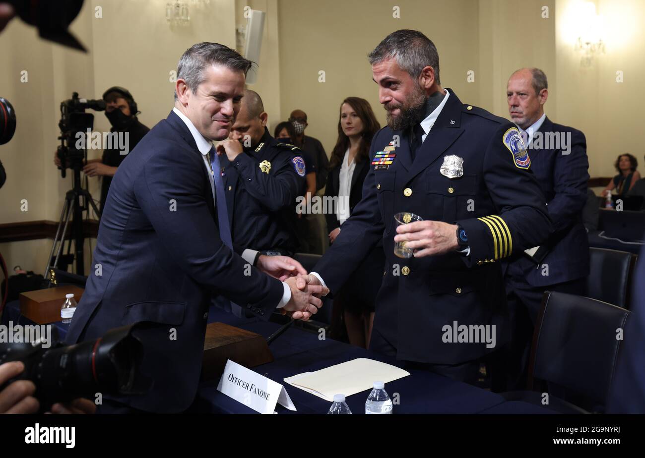 Il rappresentante degli Stati Uniti Adam Kinzinger (Repubblicano dell'Illinois) (L) saluta l'ufficiale Michael Fanone del Dipartimento di polizia Metrocercana della DC quando arriva a testimoniare prima che i membri del Comitato di selezione indaghino sull'attacco del 6 gennaio al Campidoglio degli Stati Uniti, compreso il presidente e il rappresentante democratico del Mississippi Bennie Thompson, Durante la loro prima audizione presso il Cannon House Office Building a Capitol Hill a Washington, DC, USA, 27 luglio 2021. La commissione ascolterà le testimonianze dei membri della polizia del Campidoglio degli Stati Uniti e del Metropolitan Police Department che hanno cercato di proteggere la Th Foto Stock
