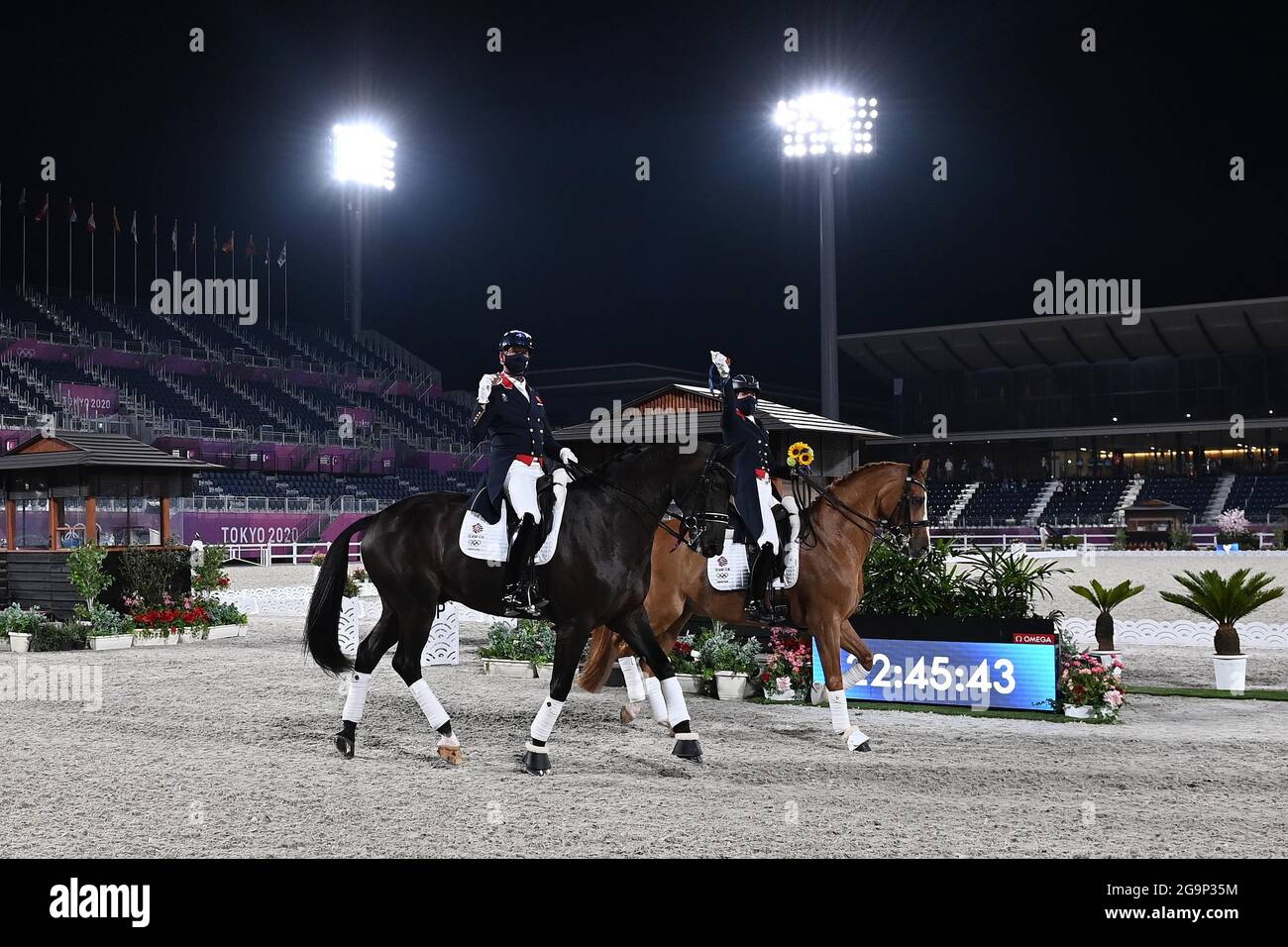 Tokyo, Giappone. 27 luglio 2021. Dressage Team. Speciale Gran Premio. Finale del team. Parco equestre. 1-1. 2Chome. Kamiyoga. Setagaya. Tokyo. Carl Hester (GBR) e Charlotte Fry (GBR) mostrano le loro medaglie di bronzo mentre completano il loro giro di honorCredit Garry Bowden/Sport in Pictures/Alamy Live News Credit: Sport in Pictures/Alamy Live News Foto Stock