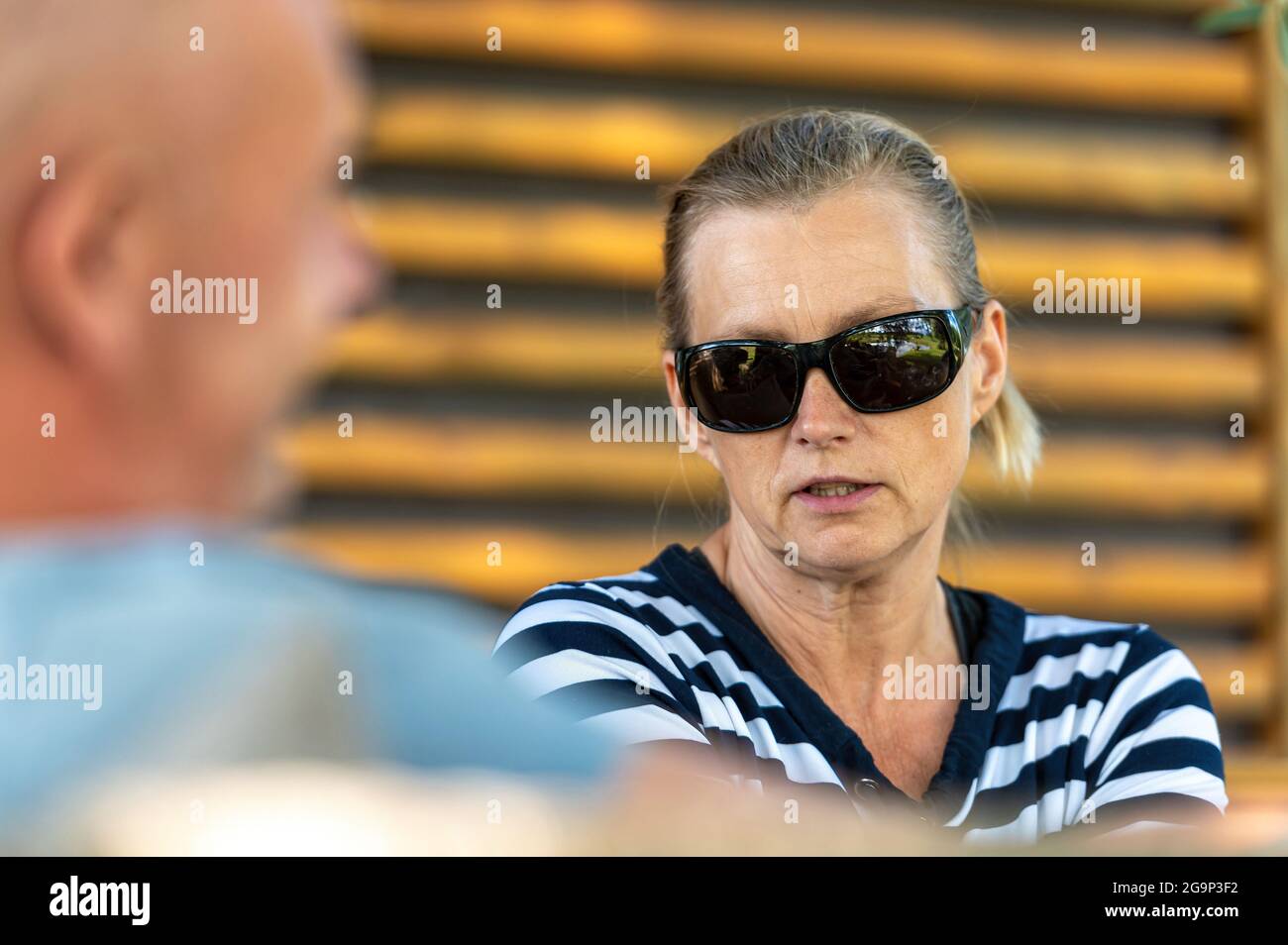 coppia di mezza età che si rilassa insieme in giardino e parla, ritratto closeup di una donna Foto Stock