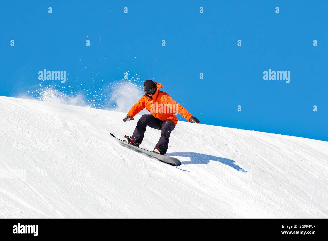 Snowboarder in azione in pista con neve fresca Foto Stock