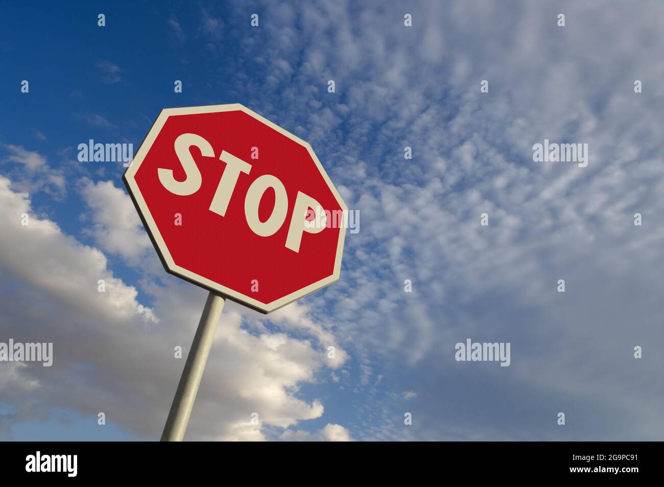 perfetta consistenza della superficie di un segnale di stop contro il cielo blu e le nuvole bianche Foto Stock