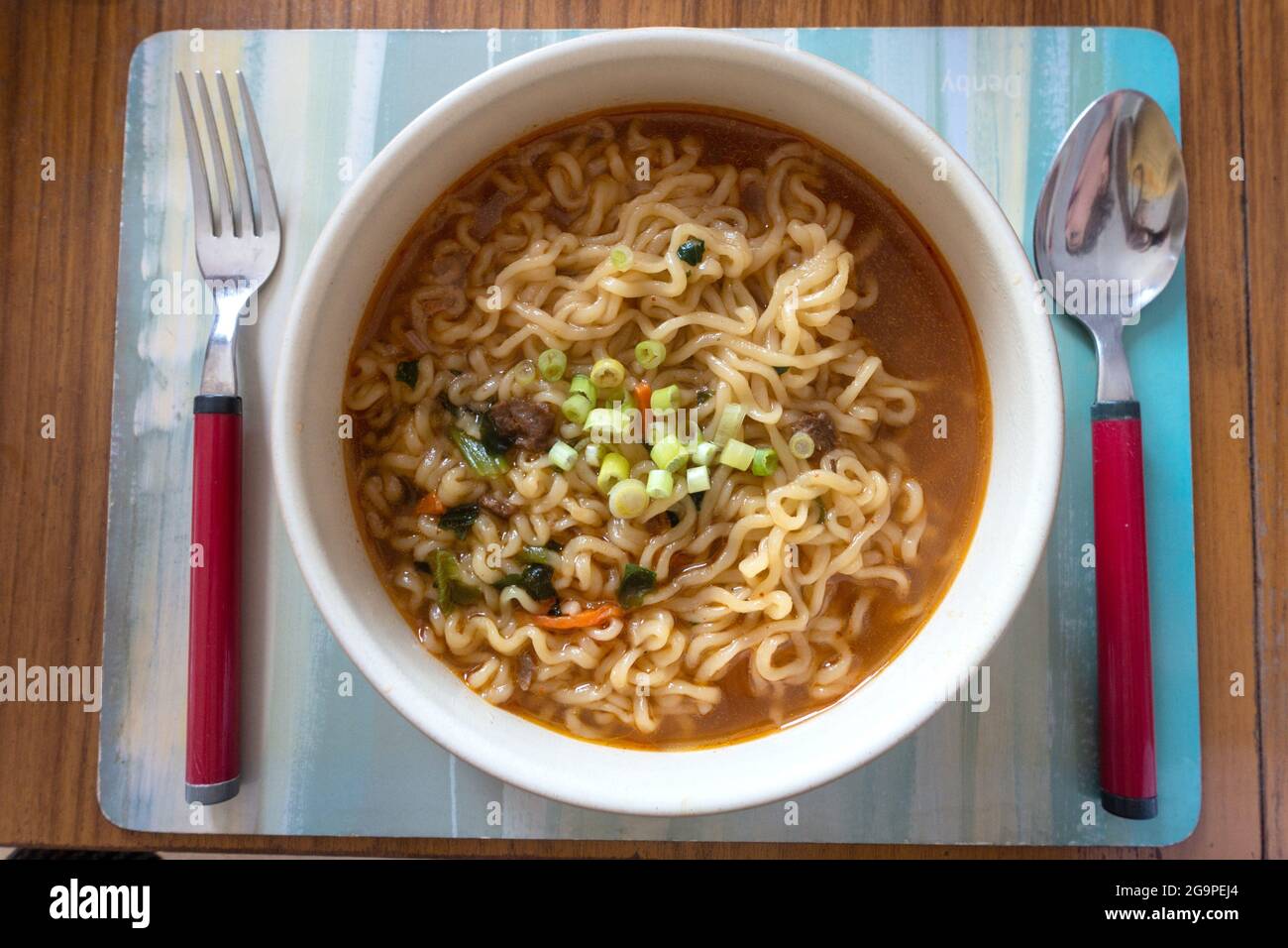 Una ciotola di noodle di udon coreani istantanei con zuppa piccante, servita in una ciotola. Foto Stock