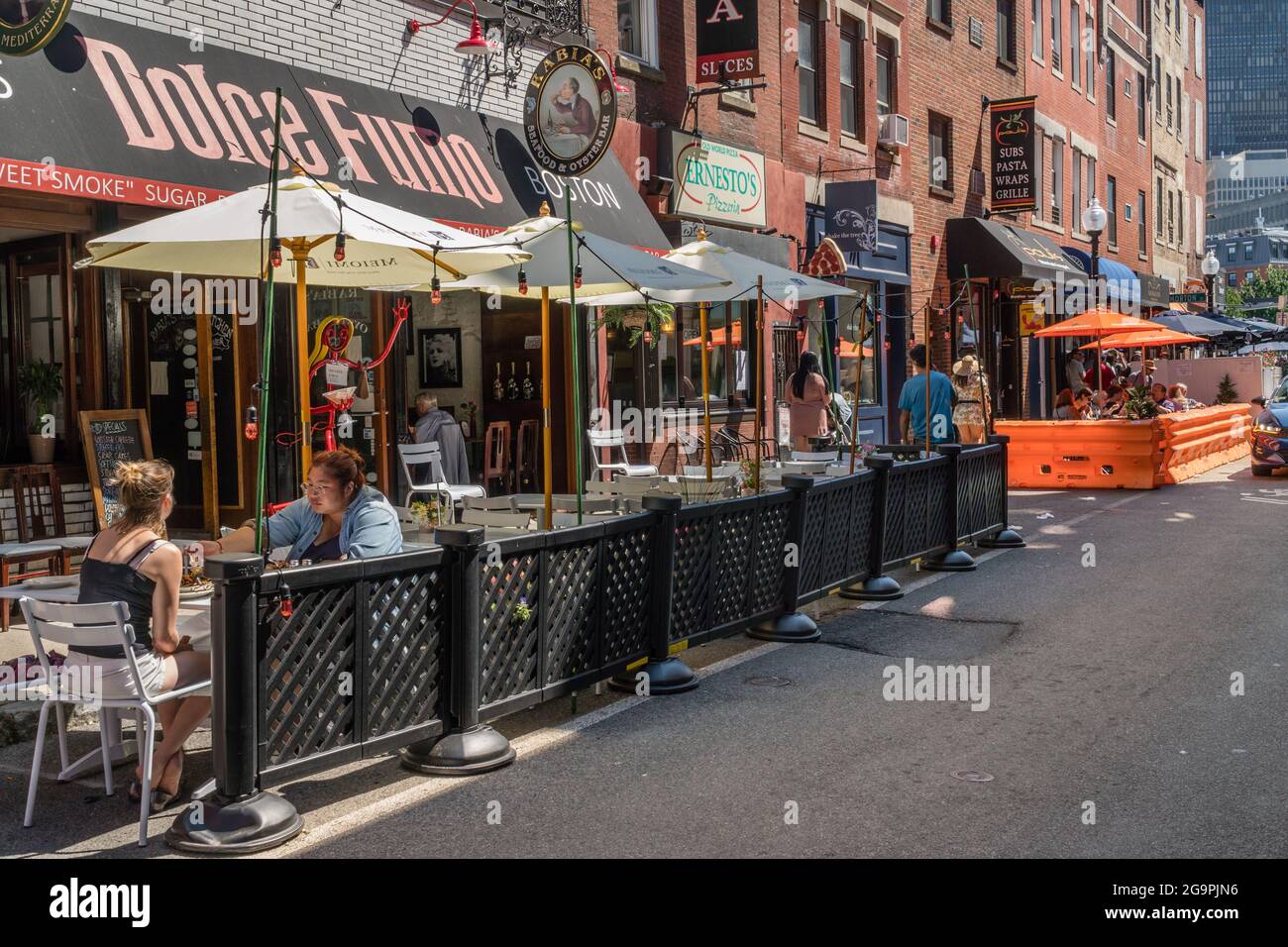 Boston, ma, US-24 luglio 2021: Scena stradale nell'area urbana del centro con posti a sedere all'aperto di recente costruzione presso ristoranti locali durante l'era Covid. Foto Stock