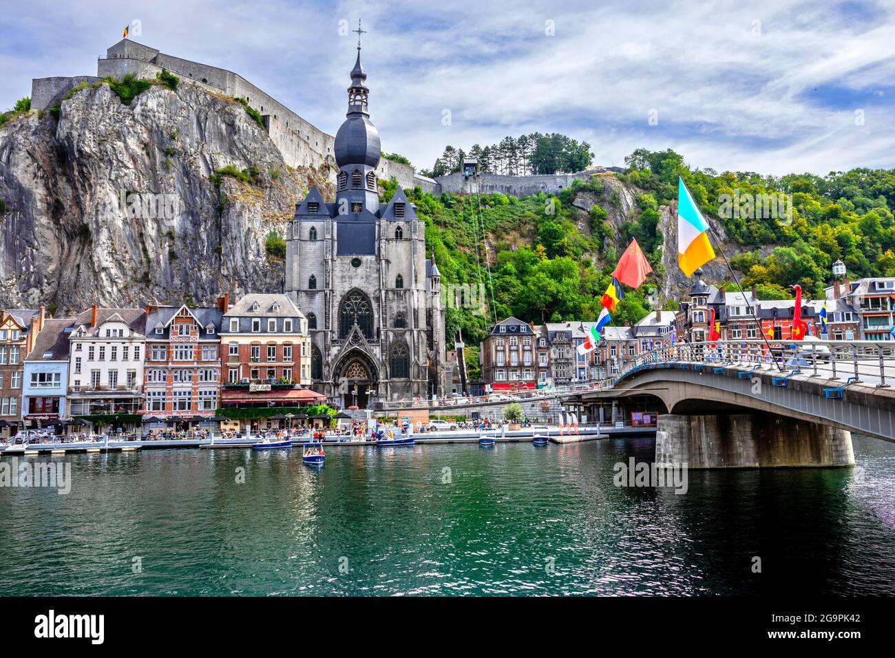 ADinant, Belgio - 19 luglio 2020: La città storica di Dinant con la bandiera belga e la cittadella sulla roccia e Collegiata di Notre-Dame Foto Stock