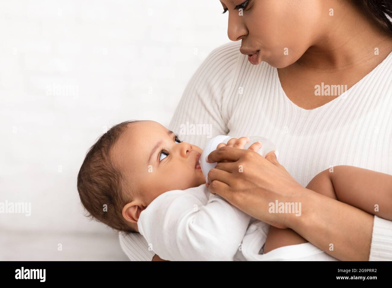 Biberon afroamericano per l'alimentazione delle mamme con latte all'interno Foto Stock