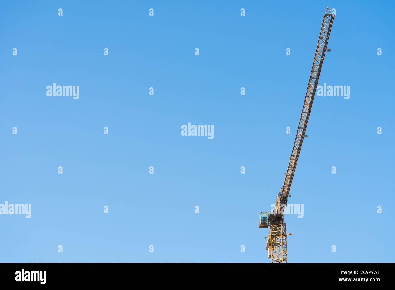 Gru alta sul cantiere con cielo blu sullo sfondo Foto Stock
