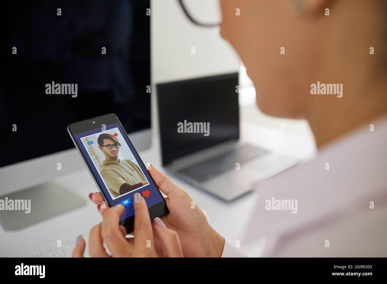 Primo piano di giovane donna che si capovolgono attraverso i profili degli uomini in app di incontri sul telefono cellulare. Foto Stock