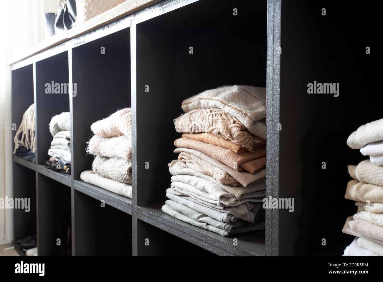 armadio aperto con un sacco di vestiti ripiegati, armadio organizzato con  vestiti impilati interni moderni e puliti di casa di lusso Foto stock -  Alamy