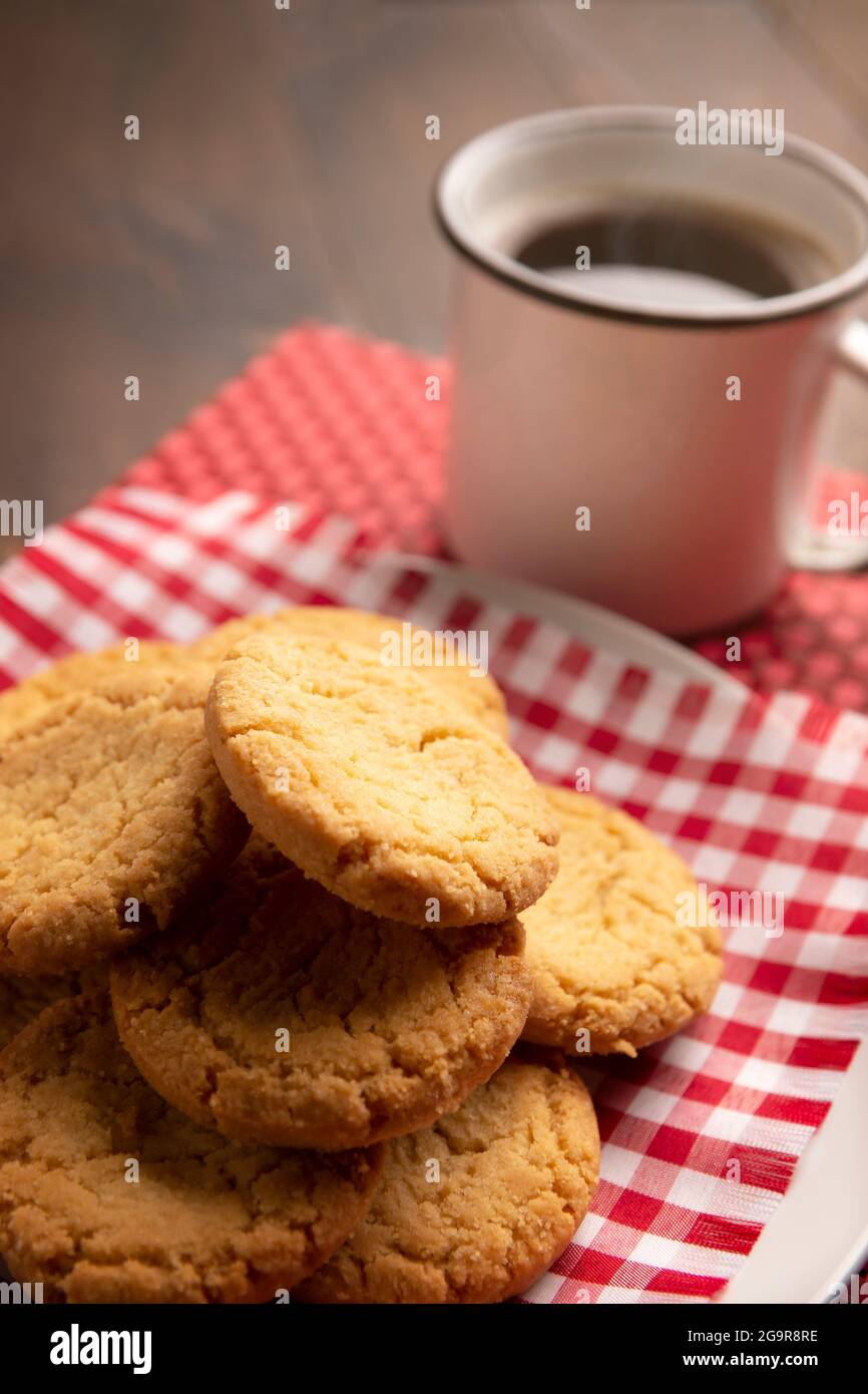 Biscotti croccanti fatti in casa e una tazza di caffè americana su un tavolo rustico in legno Foto Stock