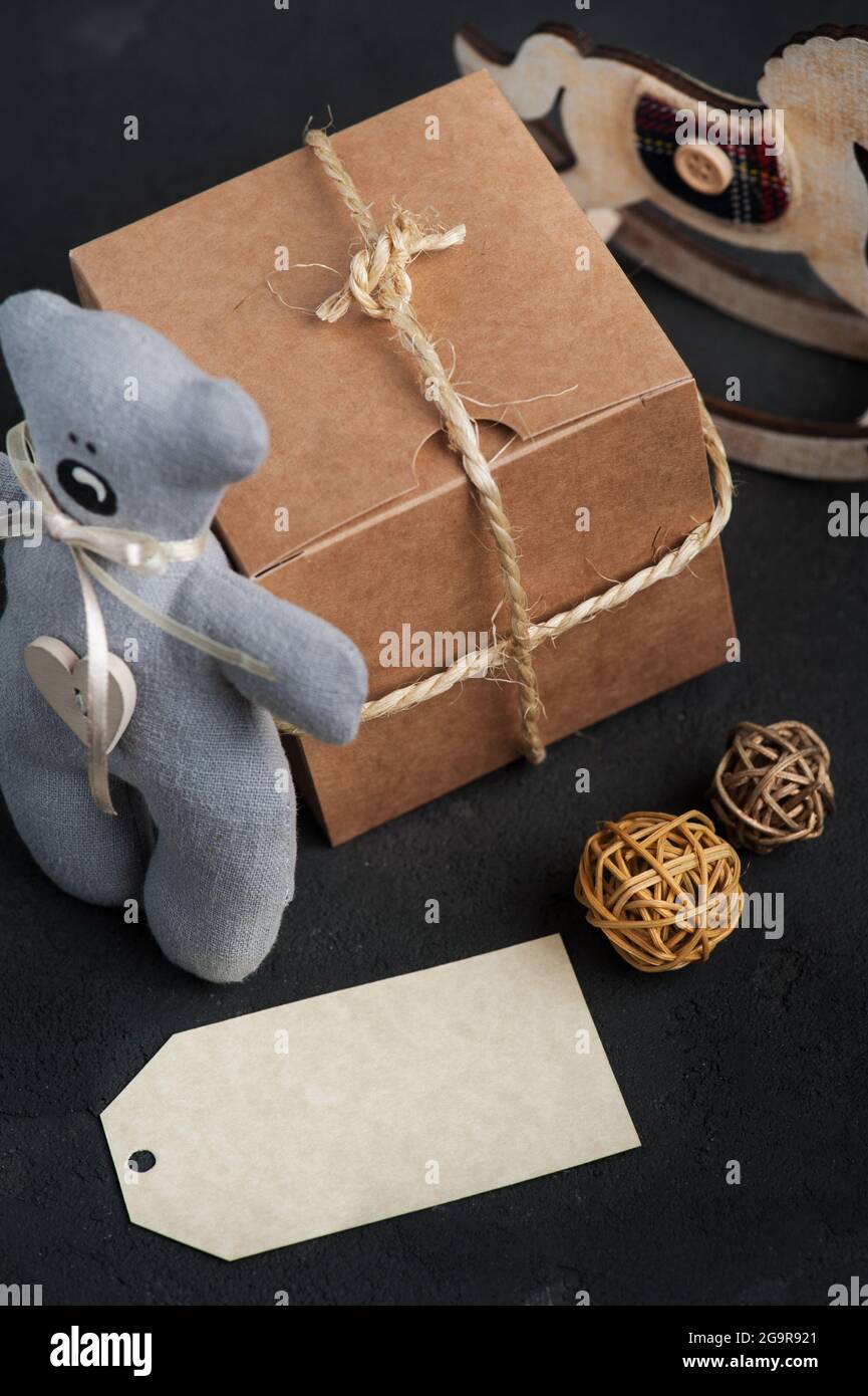 Regali di Natale su sfondo concreto. Etichetta vuota, orsacchiotto, decorazione. Compleanno o regalo di Natale Foto Stock
