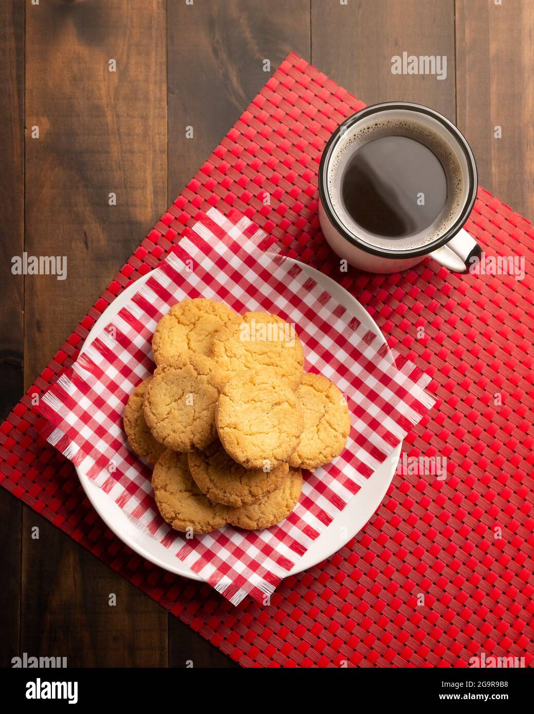 Vista dall'alto di biscotti croccanti fatti in casa e una tazza di caffè su un tavolo rustico in legno Foto Stock
