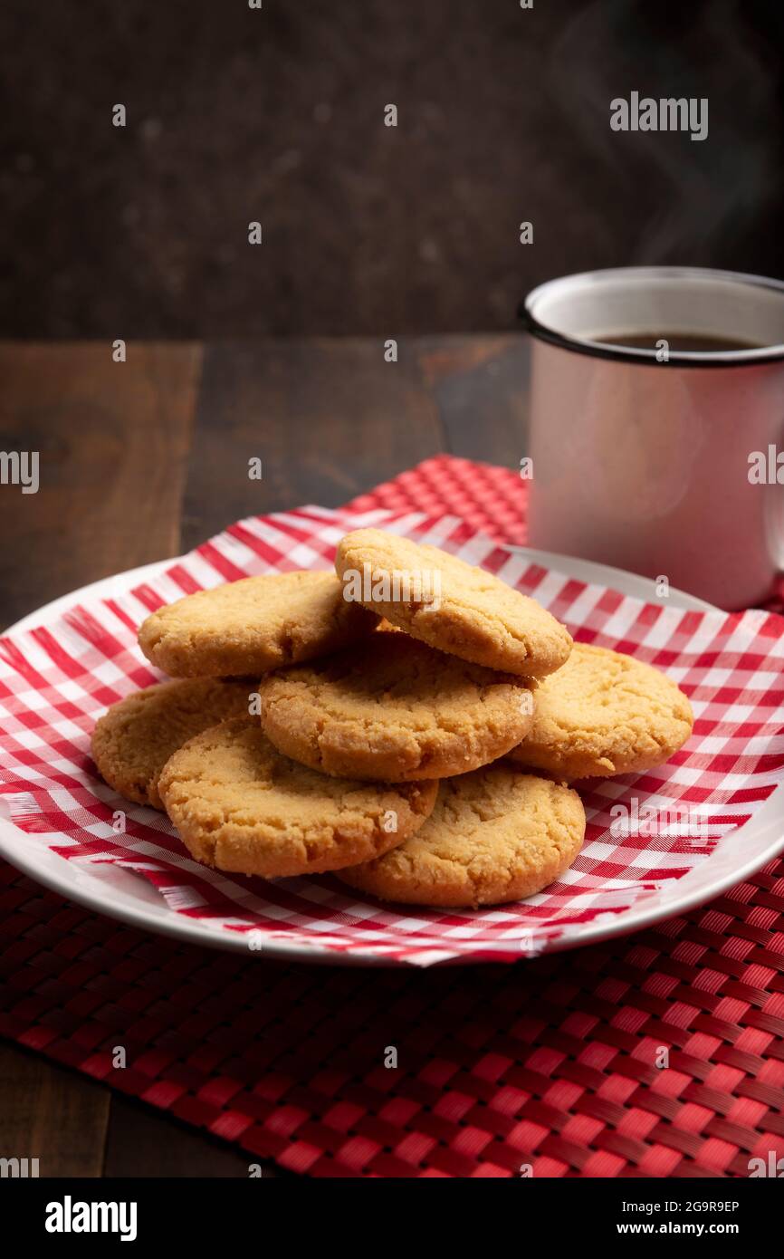 Biscotti croccanti fatti in casa e una tazza di caffè su tavolo rustico in legno Foto Stock