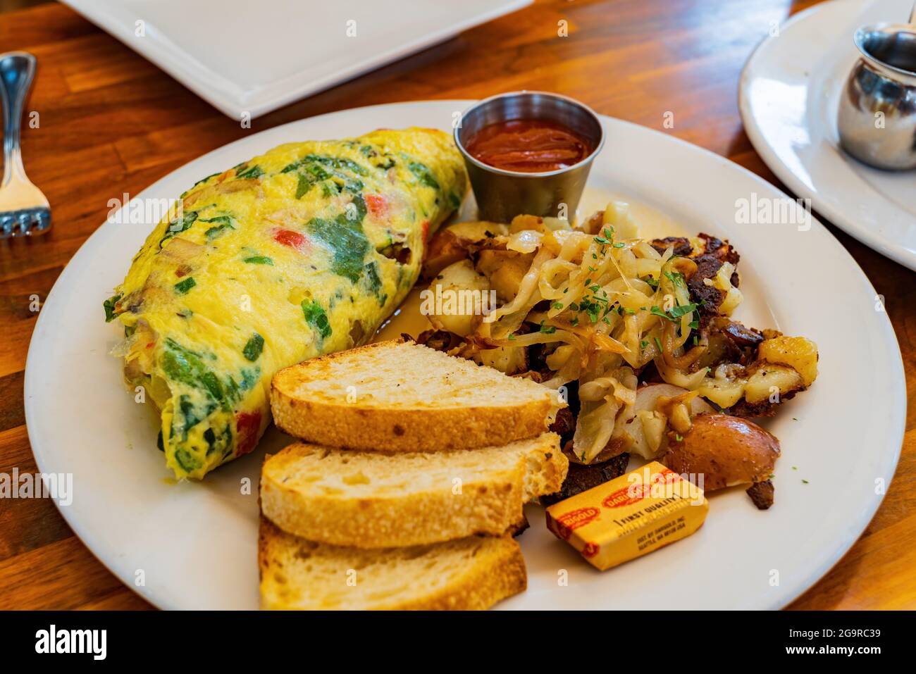 Primo piano di un piatto di Omelet con pane e patate a Los Angeles, California Foto Stock