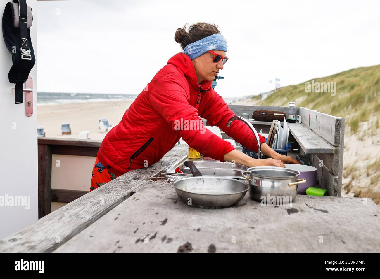 Kampen, Germania. 19 luglio 2021. Il bagnino Jana Kubikova lava i piatti dietro la stazione di bagnino. (A dpa 'il bagnino Kubikova vigila sulla vita dei bagnanti') Credit: Frank Molter/dpa/Alamy Live News Foto Stock