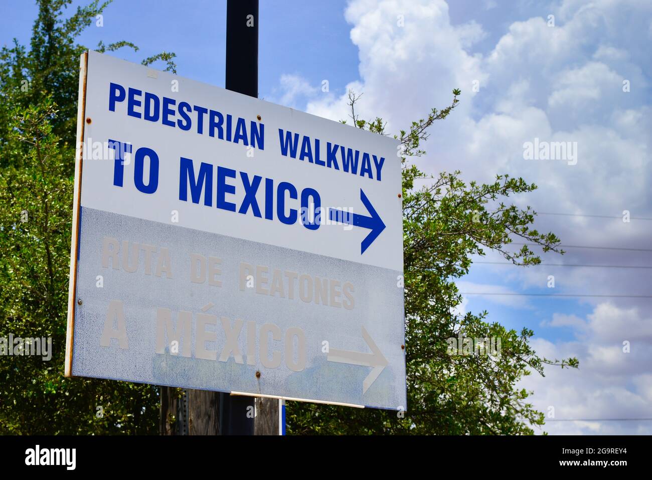 Primo piano di un cartello bianco con la freccia blu e la scritta "pedone Walkway to Mexico", al confine tra USA e Messico a Douglas, Arizona Foto Stock