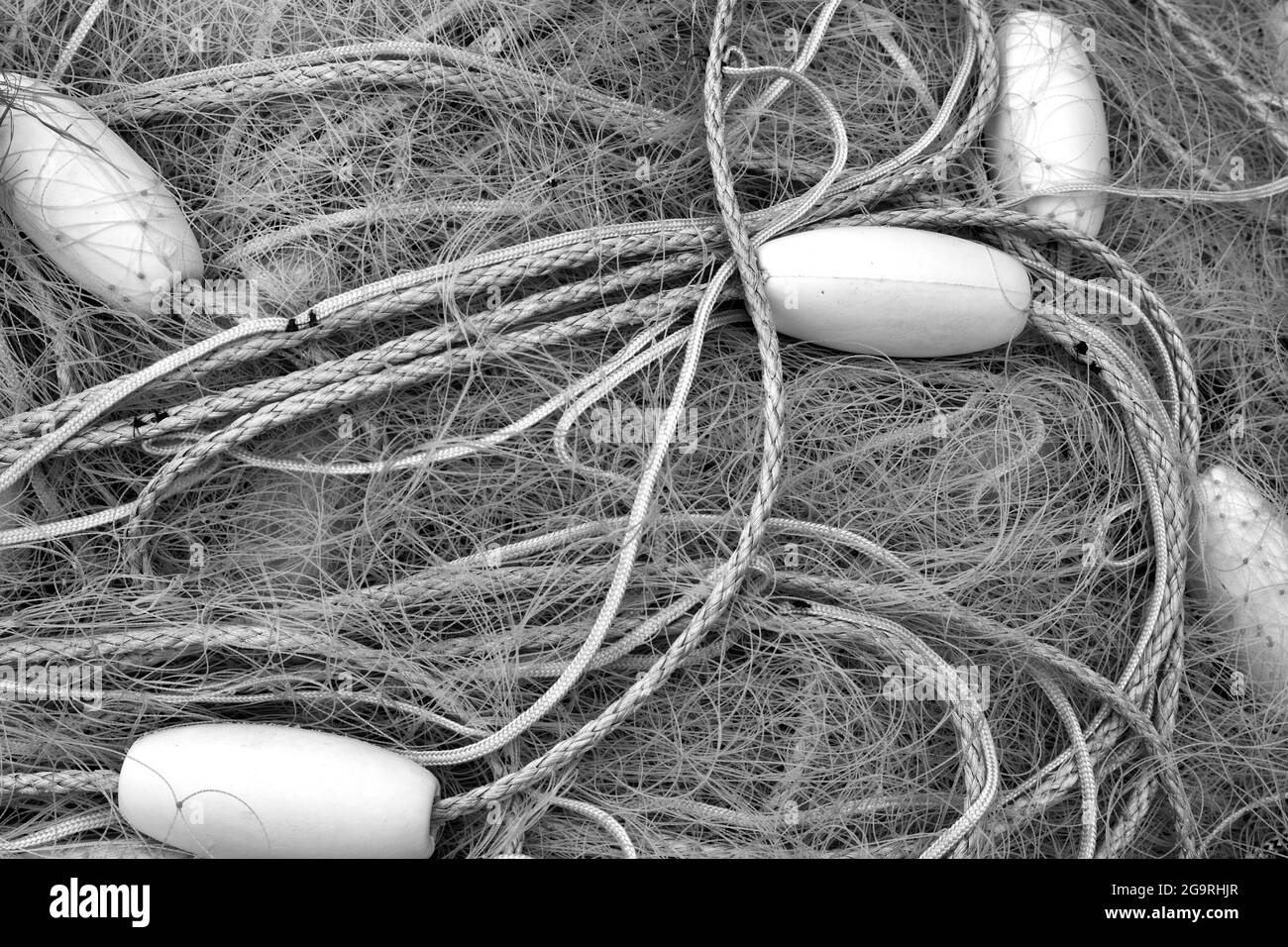 Reti da pesca, vasi di aragosta, catene e carri galleggianti sono disseminati intorno ai pescherecci da traino attivi sulla spiaggia di East Hill, Hastings. Foto Stock