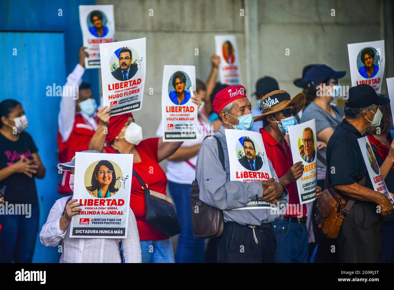 I sostenitori della FMLN tengono in mano i cartelli degli ex funzionari governativi durante una protesta contro l'arresto. L'ufficio del procuratore generale ha arrestato cinque ex funzionari del governo del primo governo FMLN (Frente Farabundo Martí para la Liberación Nacional), mentre altri cinque, tra cui l'ex vice presidente, Sanchez Cerén, sono voluti ma ancora da arrestare. I leader del FMLN e i movimenti per i diritti umani lo hanno definito una prigionia politica in cui si cita che il processo dovuto non era garantito e il procuratore generale che si è insediato dopo il partito del presidente Nayib Bukele al Congresso ha cacciato la a costituzionale Foto Stock