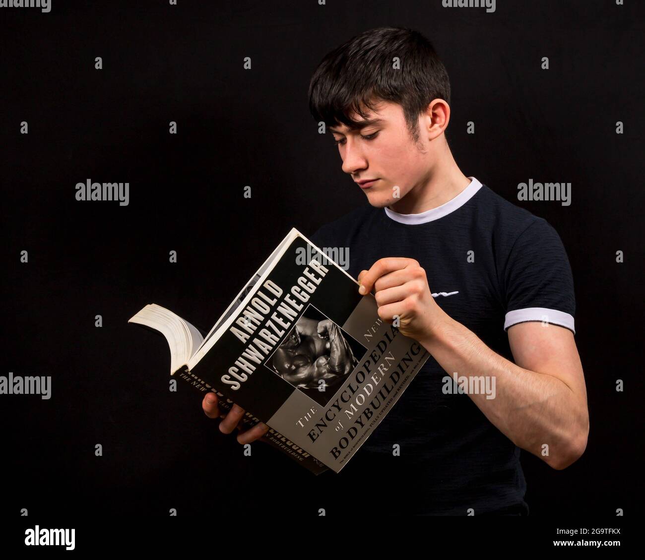 Giovani uomini che leggono un libro di bodybuilding Foto Stock