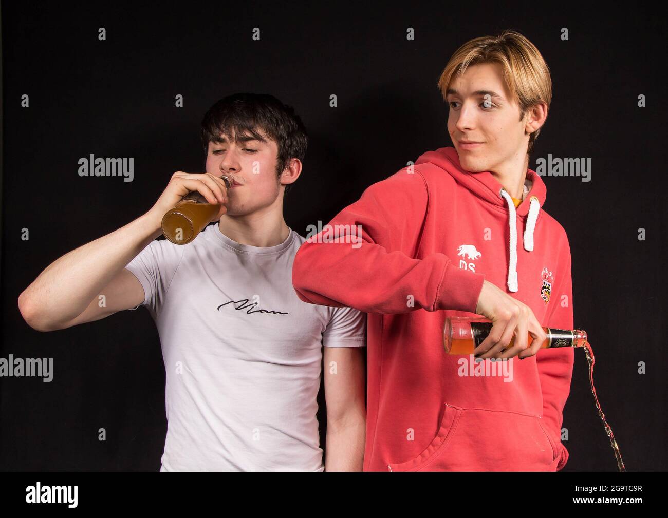 Gioventù maschile di fronte alla pressione dei pari per bere alcol Foto Stock