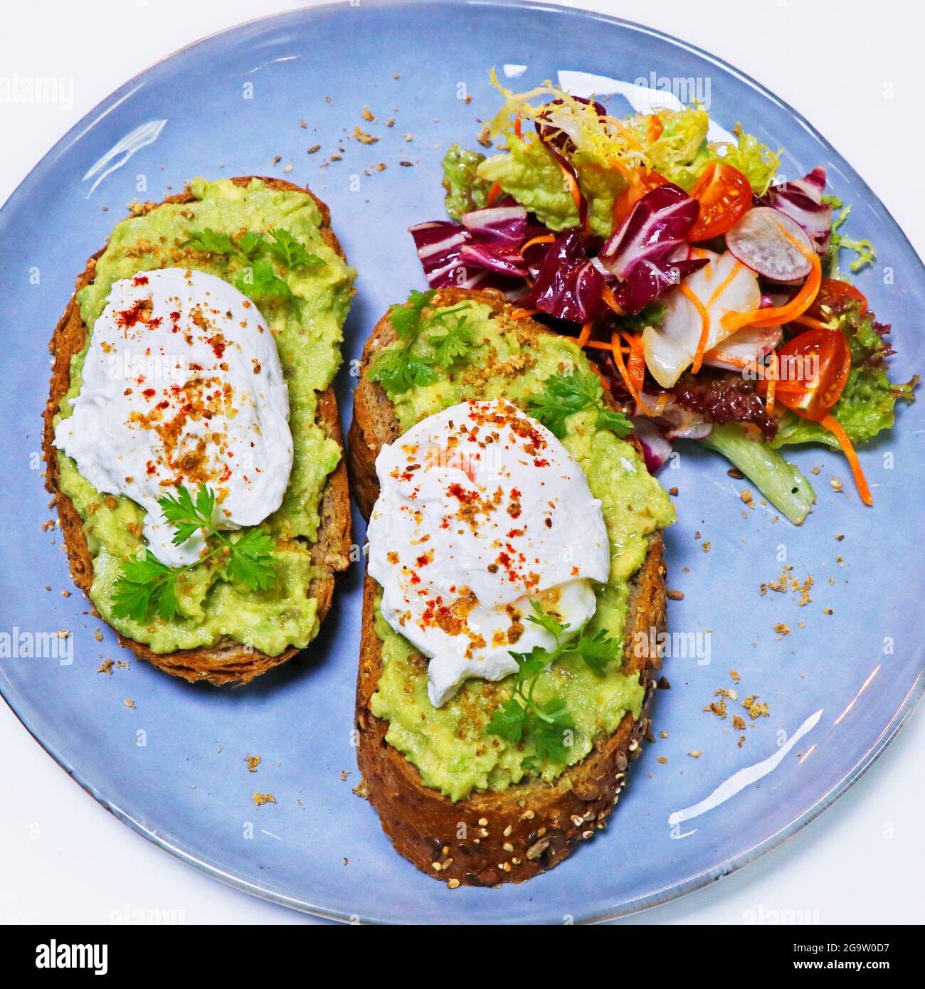 Uova biologiche strapazzate su pane tostato con asparagi, pomodoro e lattuga mista, colazione estiva Foto Stock