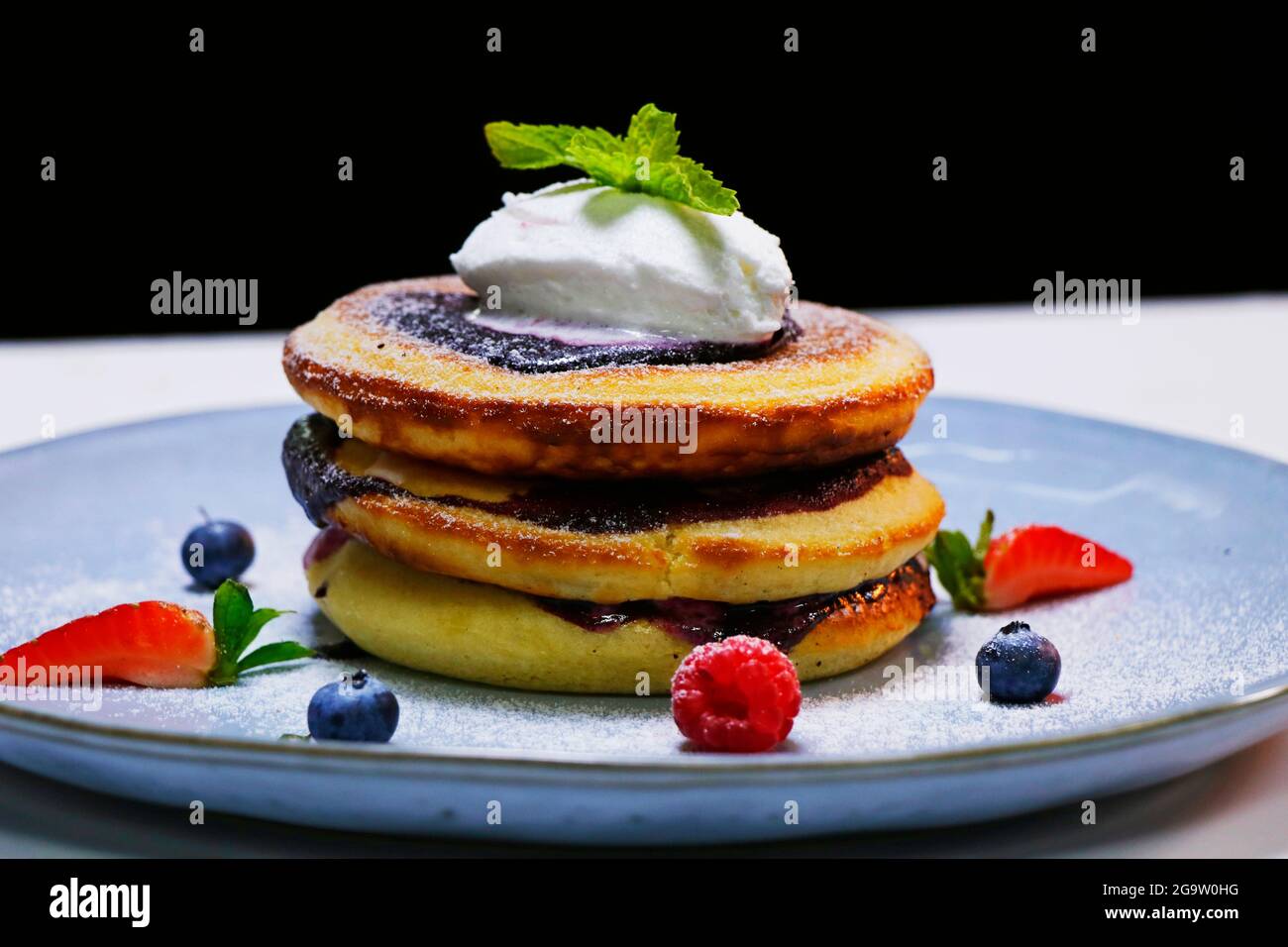 Sana colazione estiva, frittelle americane classiche fatte in casa con frutti di bosco freschi e miele Foto Stock