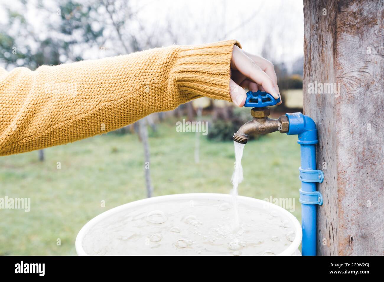 Una mano che apre un rubinetto dell'acqua Foto Stock