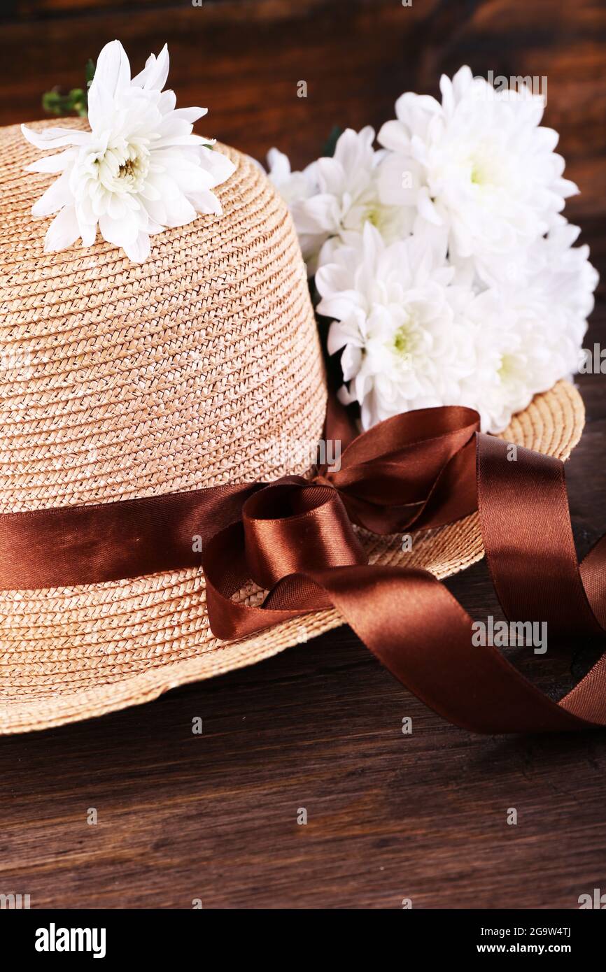 Cappello con fiori su sfondo di legno Foto stock - Alamy