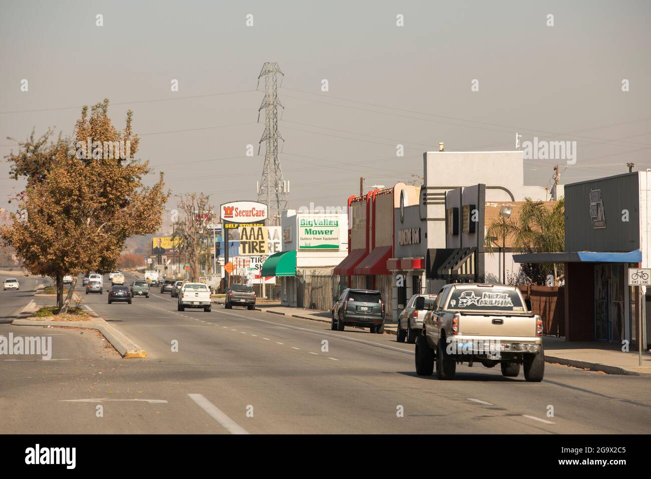 Bakersfield, California, USA - 01 dicembre 2020: Le automobili passano lungo Chester Avenue sotto un cielo inquinato. Foto Stock