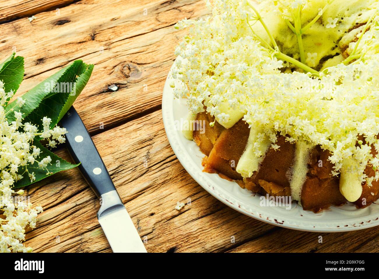 Torta estiva fatta in casa guarnita con fiori più anziani. Foto Stock