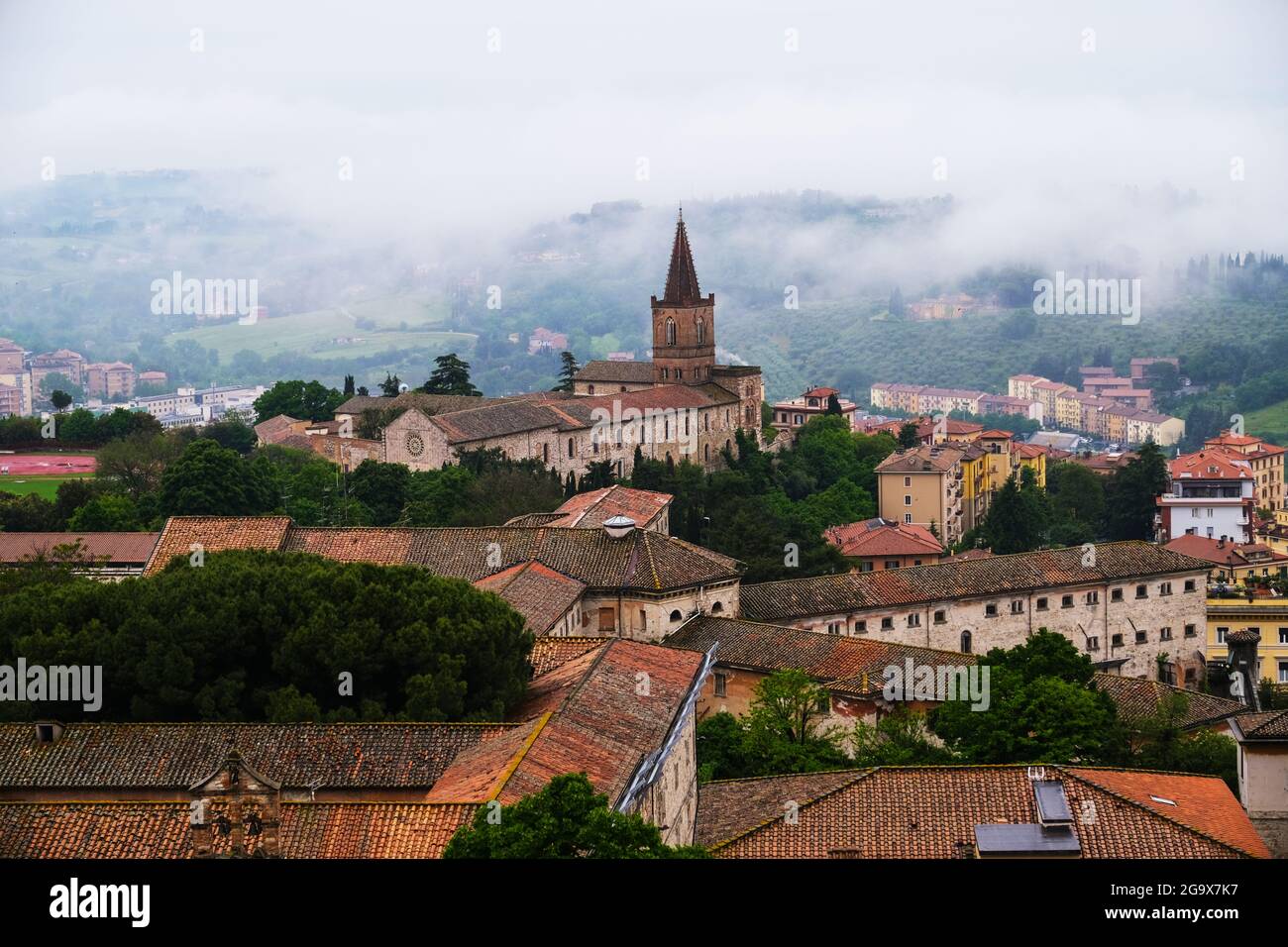 Nebbia al mattino presto sulle colline umbre e la città di Perugia in Italia Foto Stock