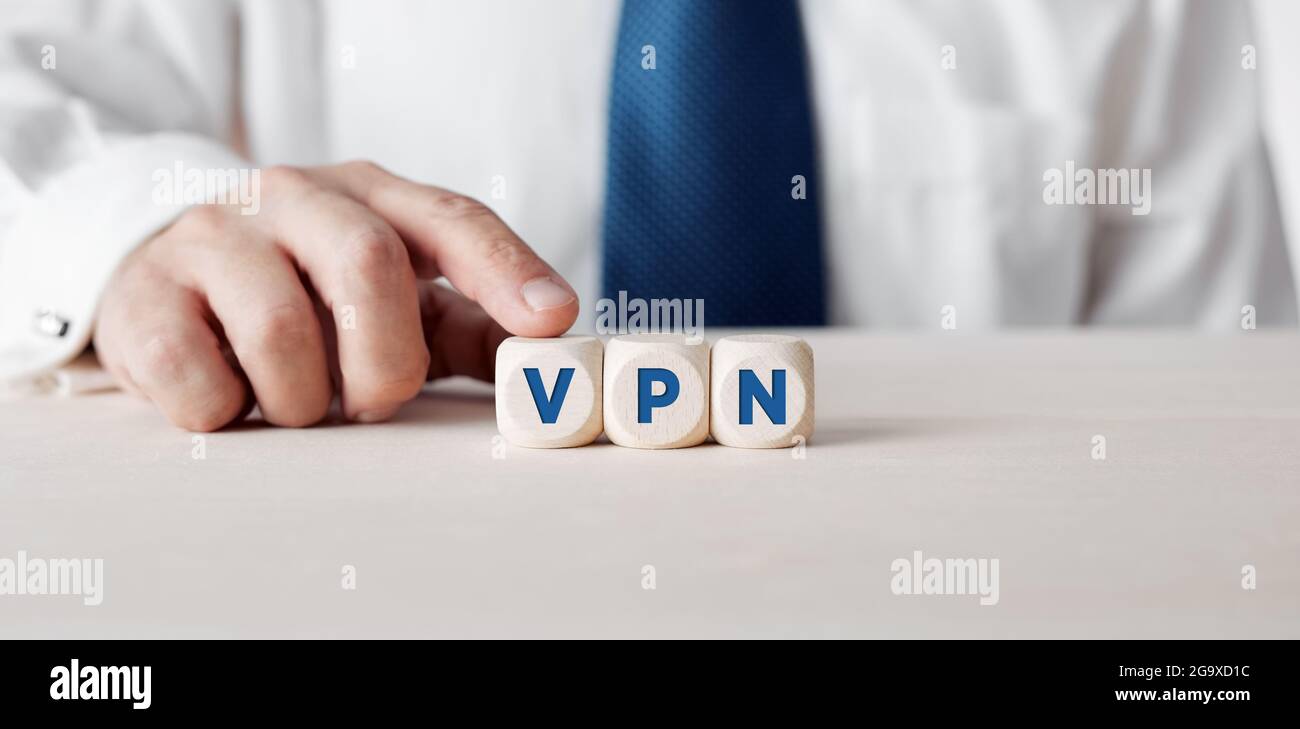 Uomo d'affari premendo il dito sui cubetti di legno con la parola VPN Virtual Private Network. Foto Stock
