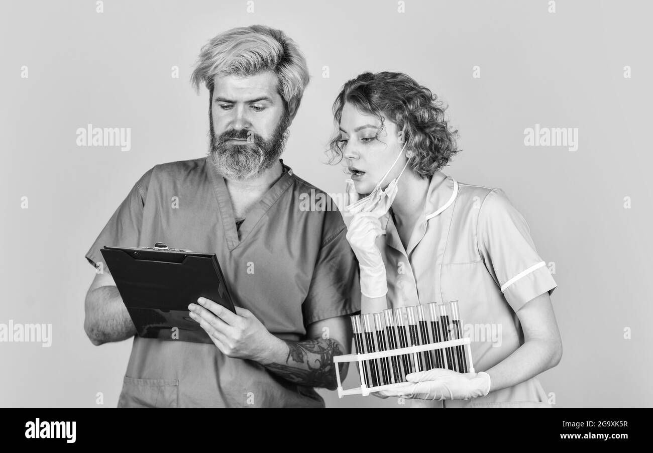 Campioni di sangue. Rimedio antivirus in laboratorio. Maschera di respirazione per medici. Vaccino contro l'infezione e analisi del sangue. Colleghi di lavoratori medici. Coppia medica Foto Stock