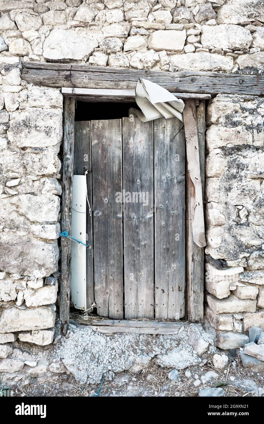 Antico fienile rustico in legno porta di un fienile abbandonato in pietra Foto Stock